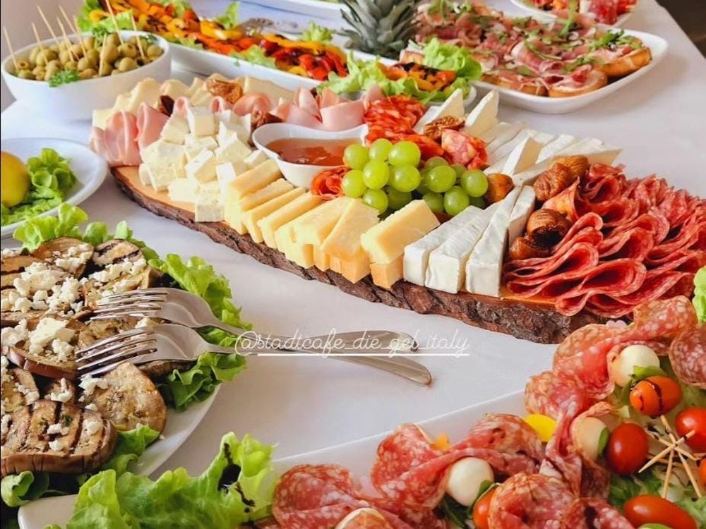Kaltes Buffet mit Antipasti, Käse, Salami und Obst, aufgebaut im Stadtcafé