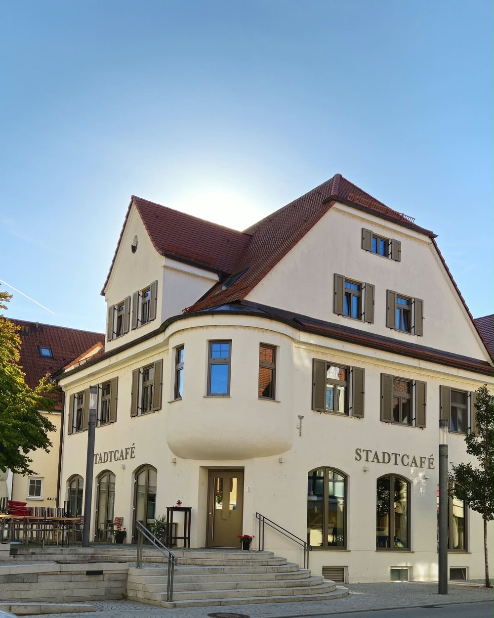 Das Stadtcafé Dietenheim an der Königstraße 64 — Eckhaus mit Erker, Terrasse und dem Schriftzug Stadtcafé über den Fenstern